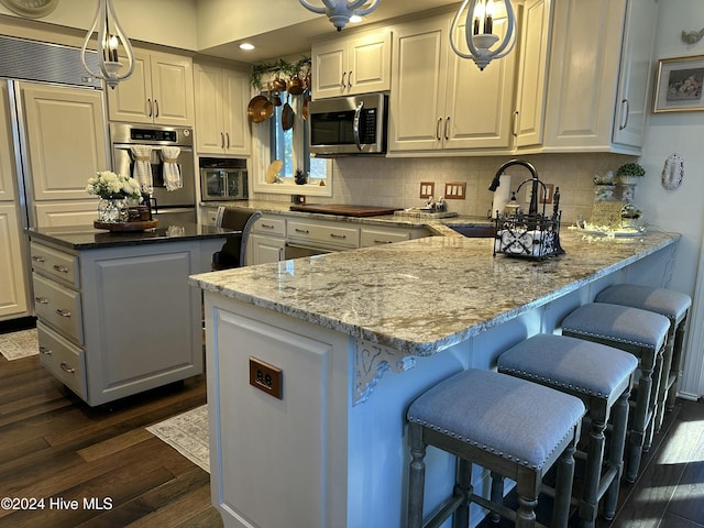 kitchen featuring light stone counters, hanging light fixtures, and white cabinets