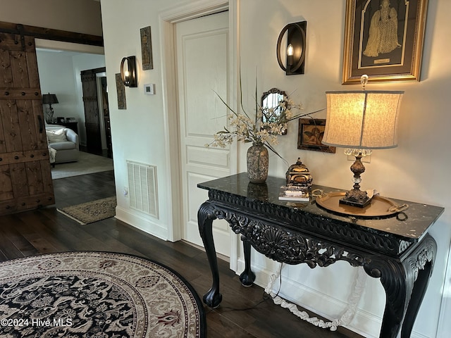 hallway featuring dark hardwood / wood-style flooring and a barn door