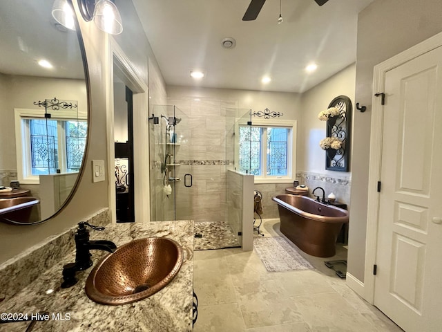 bathroom with ceiling fan, vanity, and plus walk in shower