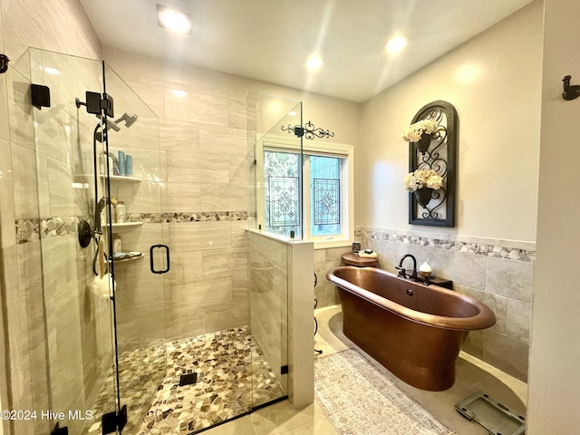 bathroom featuring tile patterned flooring, separate shower and tub, and tile walls