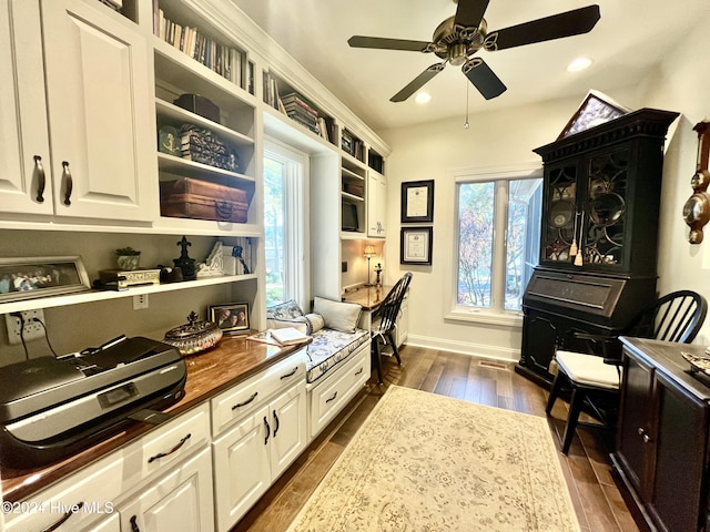 interior space with light stone counters, ceiling fan, dark wood-type flooring, and white cabinets