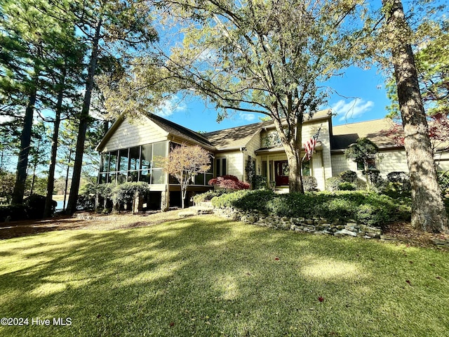 view of front of property with a sunroom and a front yard