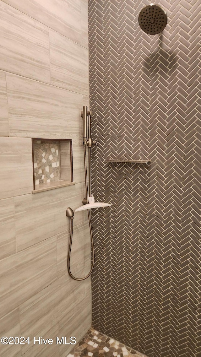 interior details featuring a tile shower