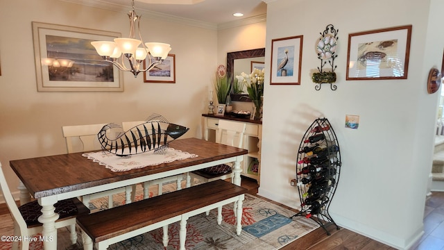 dining space with dark hardwood / wood-style floors, crown molding, and a chandelier