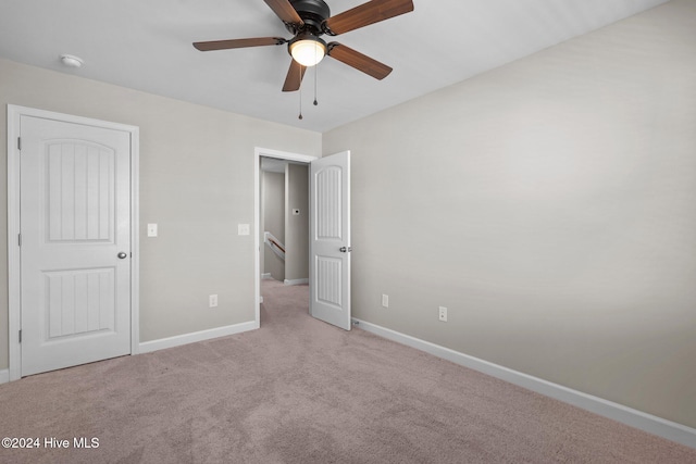 unfurnished bedroom featuring ceiling fan and light colored carpet