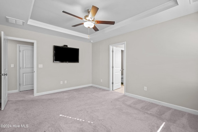 carpeted spare room featuring a tray ceiling, ceiling fan, and ornamental molding