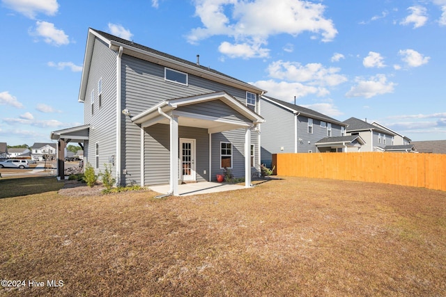 rear view of property featuring a yard and a patio