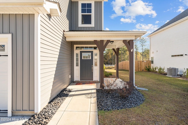 doorway to property with a yard and cooling unit