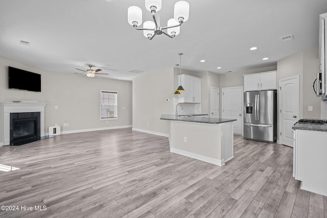 kitchen with white cabinetry, pendant lighting, appliances with stainless steel finishes, ceiling fan with notable chandelier, and light wood-type flooring