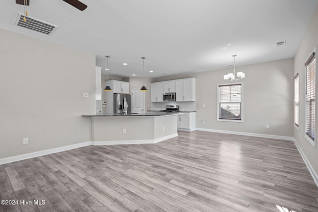 kitchen featuring white cabinetry, hanging light fixtures, kitchen peninsula, light hardwood / wood-style floors, and appliances with stainless steel finishes