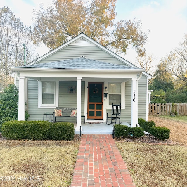 bungalow-style home featuring a porch and a front lawn