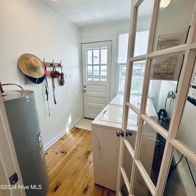 laundry area featuring washing machine and dryer, water heater, and wood-type flooring