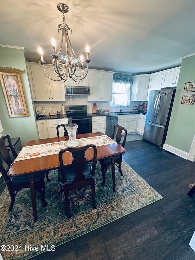 dining room featuring dark hardwood / wood-style floors, ornamental molding, sink, and a chandelier