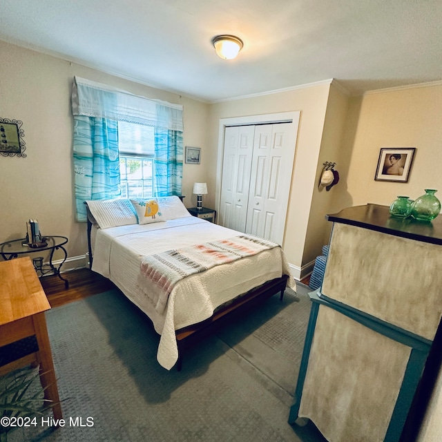 bedroom with crown molding, a closet, and dark wood-type flooring