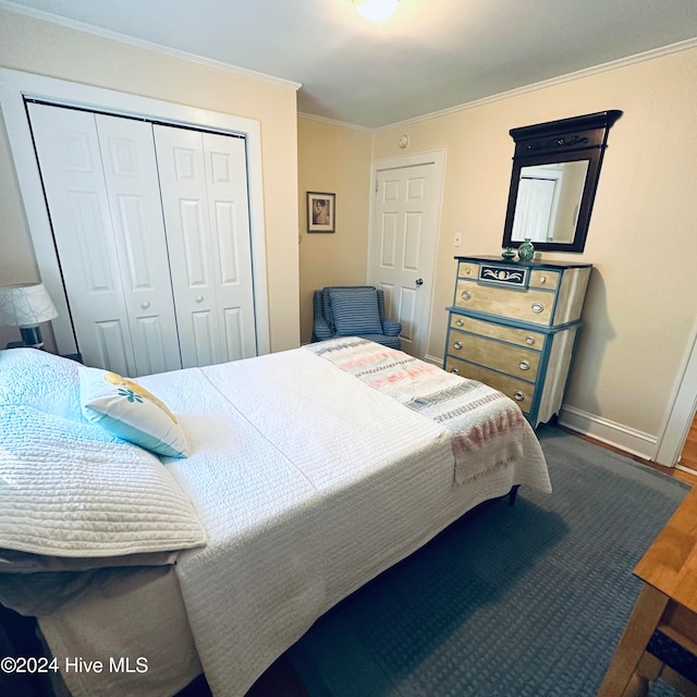 bedroom with dark hardwood / wood-style floors, crown molding, and a closet