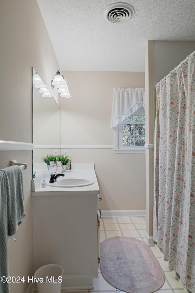 bathroom featuring tile patterned floors, vanity, a shower with curtain, and a textured ceiling