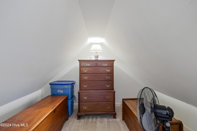 interior space featuring light colored carpet and lofted ceiling