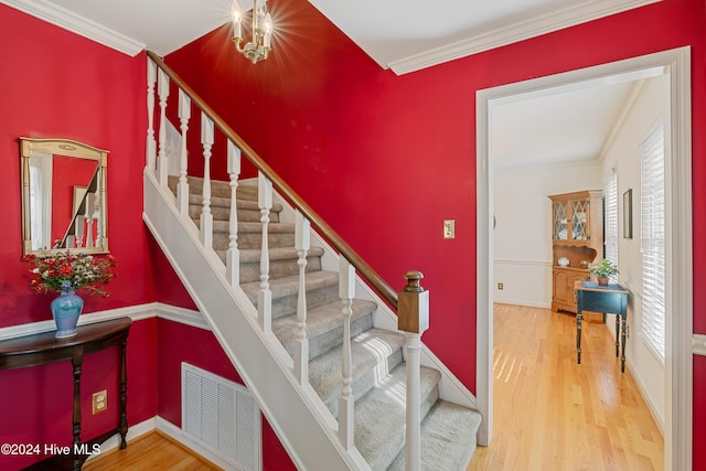 staircase with wood-type flooring and ornamental molding