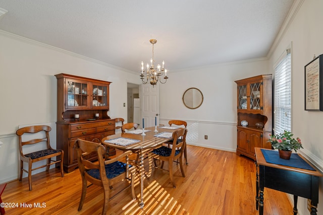 dining area featuring a notable chandelier, light hardwood / wood-style floors, and ornamental molding