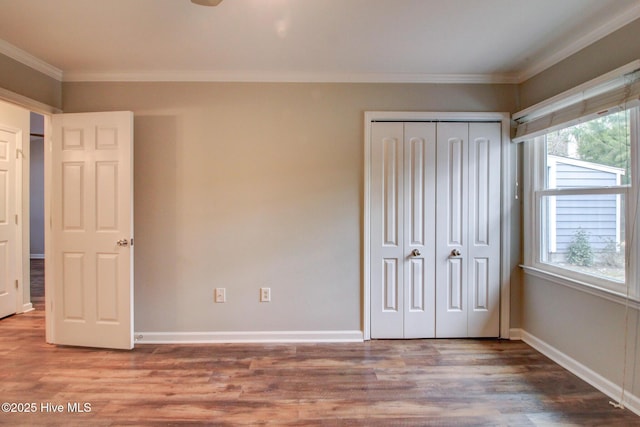 unfurnished bedroom with hardwood / wood-style floors, a closet, and ornamental molding