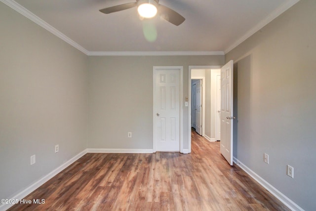 empty room featuring hardwood / wood-style flooring, ceiling fan, and crown molding