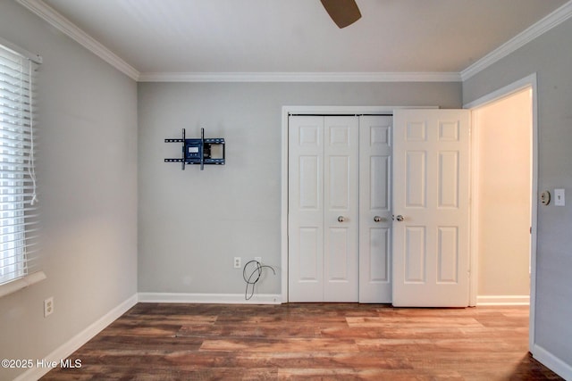 unfurnished bedroom featuring ceiling fan, wood-type flooring, crown molding, and a closet