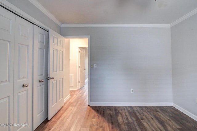 unfurnished bedroom with a closet, wood-type flooring, and ornamental molding