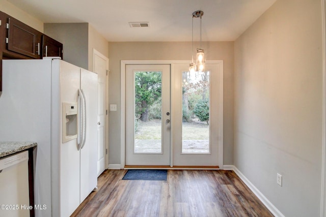 doorway featuring a chandelier and dark wood-type flooring