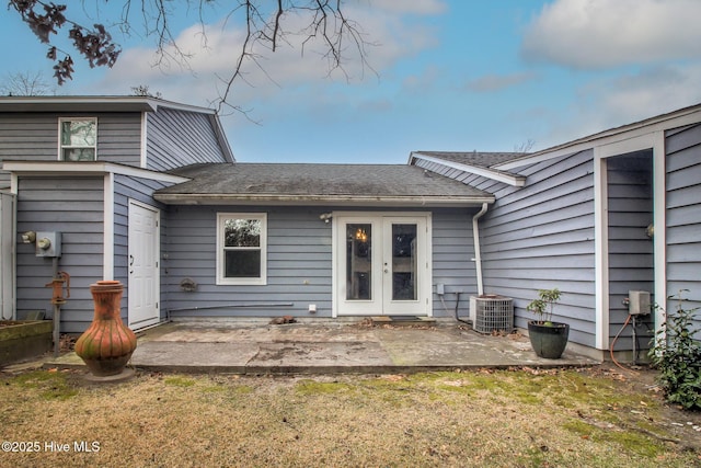 back of property with french doors, central air condition unit, a patio area, and a lawn