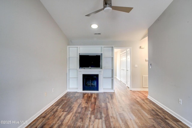 unfurnished living room featuring hardwood / wood-style floors, vaulted ceiling, and ceiling fan