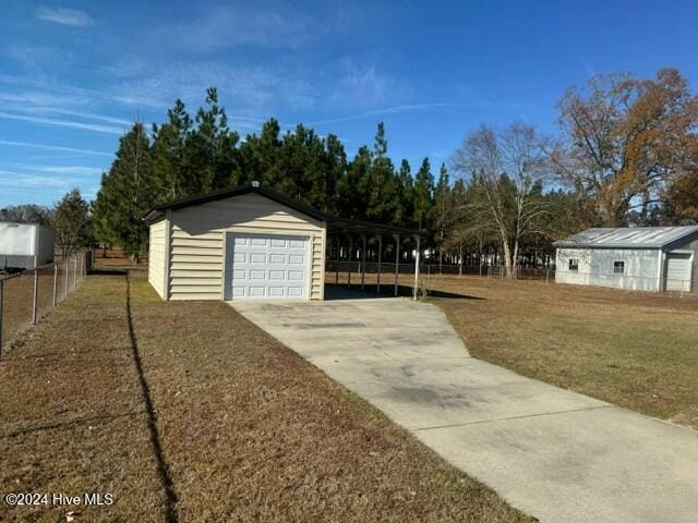 garage featuring a carport and a yard