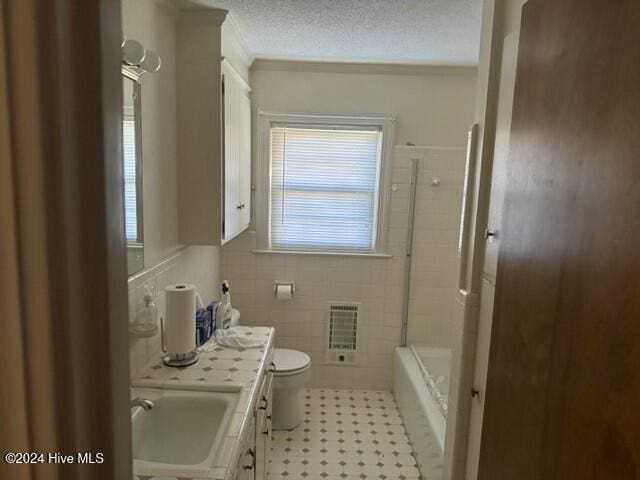 full bathroom featuring plenty of natural light, a textured ceiling, vanity, and heating unit