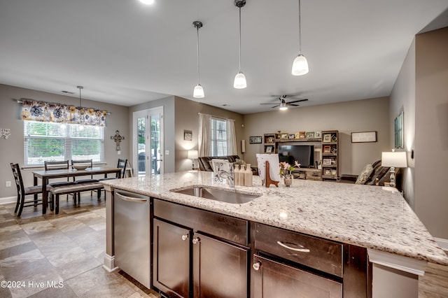 kitchen with light stone countertops, ceiling fan, sink, pendant lighting, and dark brown cabinets