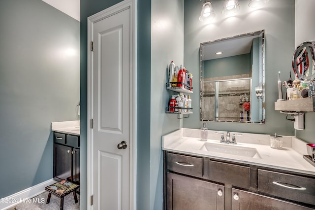 bathroom featuring a shower with door and vanity