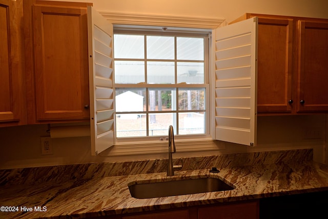 kitchen with light stone counters and sink