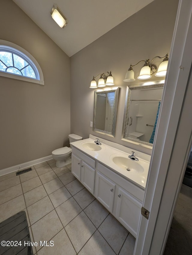 bathroom with tile patterned floors, walk in shower, vanity, and toilet