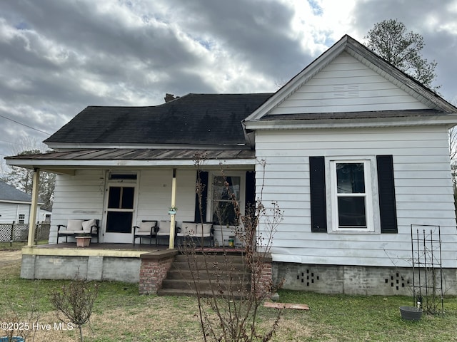 view of front of house featuring covered porch and a front lawn