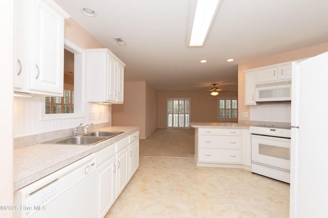 kitchen featuring white appliances, sink, kitchen peninsula, ceiling fan, and white cabinetry