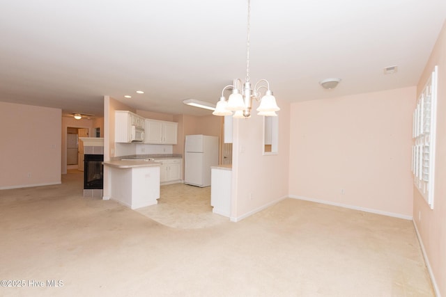 kitchen featuring white cabinetry, a chandelier, decorative light fixtures, white appliances, and light carpet