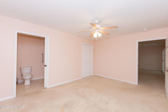 unfurnished bedroom featuring ensuite bath, ceiling fan, a closet, and light colored carpet