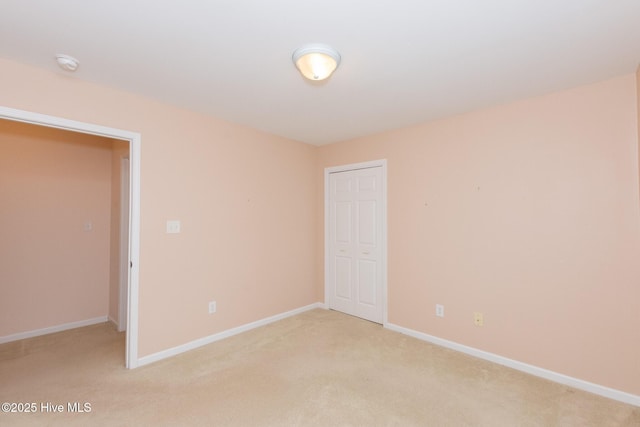 unfurnished bedroom featuring a closet and light colored carpet