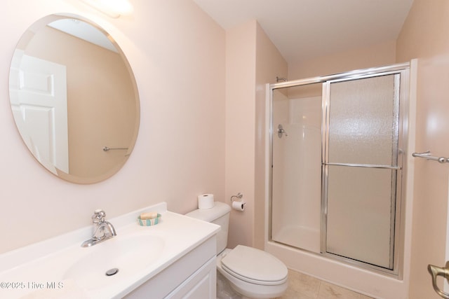 bathroom featuring tile patterned flooring, vanity, toilet, and an enclosed shower