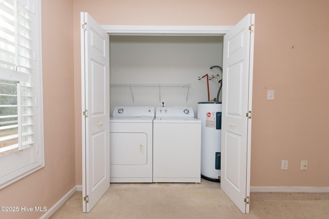 clothes washing area with electric water heater and separate washer and dryer