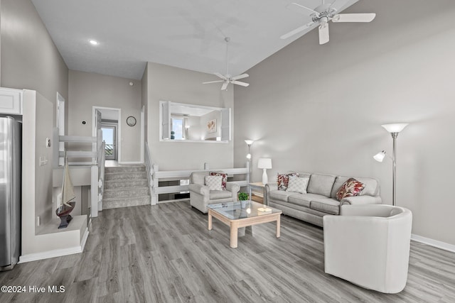 living room featuring high vaulted ceiling and light wood-type flooring