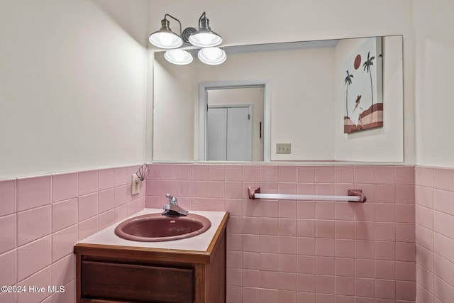 bathroom featuring vanity and tile walls