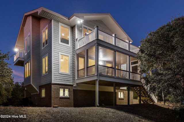 back house at dusk featuring a balcony