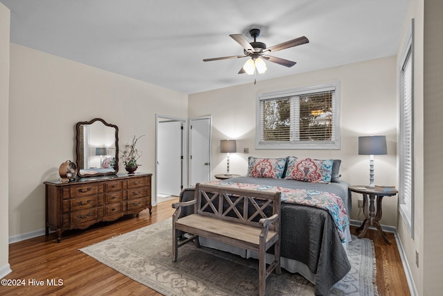 bedroom with wood-type flooring, access to outside, and ceiling fan