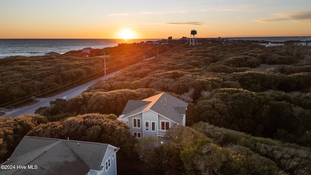 aerial view at dusk featuring a water view