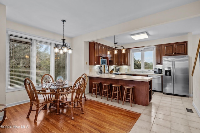 dining area with light hardwood / wood-style floors and a notable chandelier