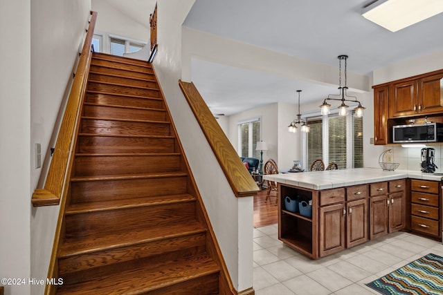 stairs featuring tile patterned floors and a chandelier